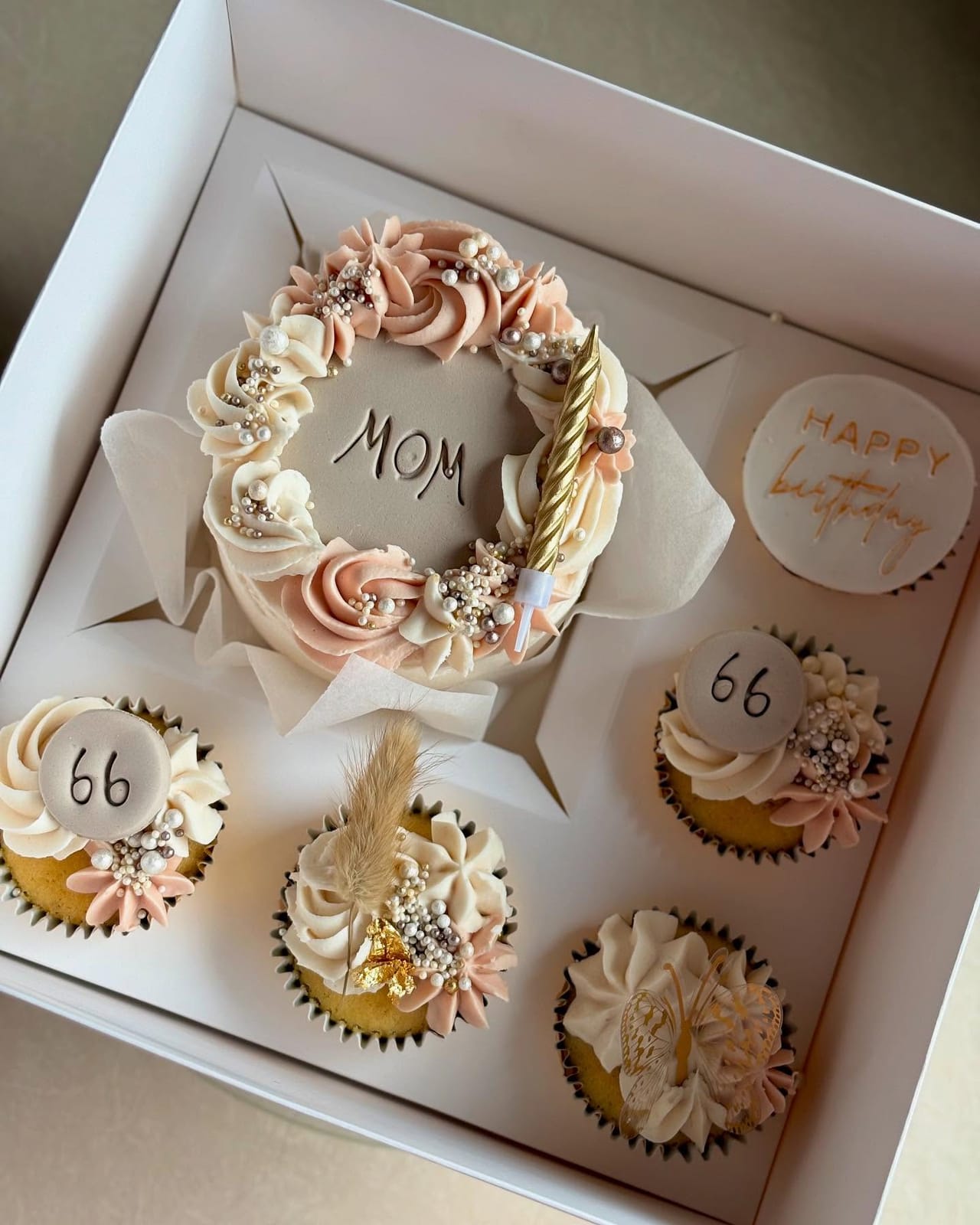 Blush and cream gift box with a piped bento cake reading Mom and matching cupcakes, by Baked by Mono